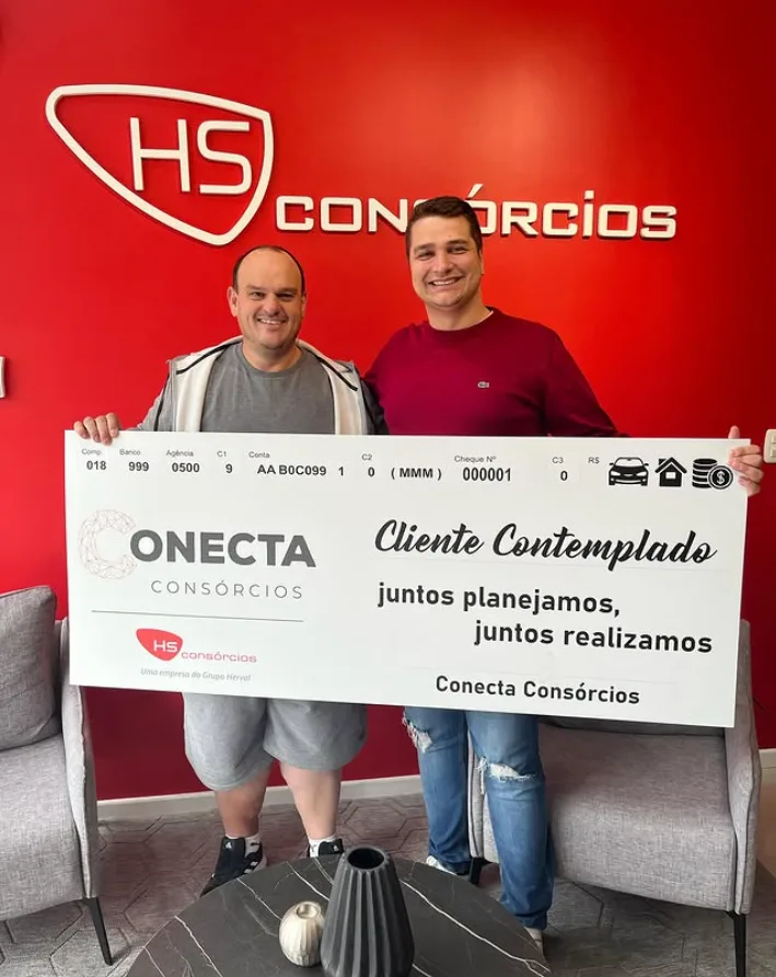 Cliente contemplado segurando carta da Conecta Cons&oacute;rcios